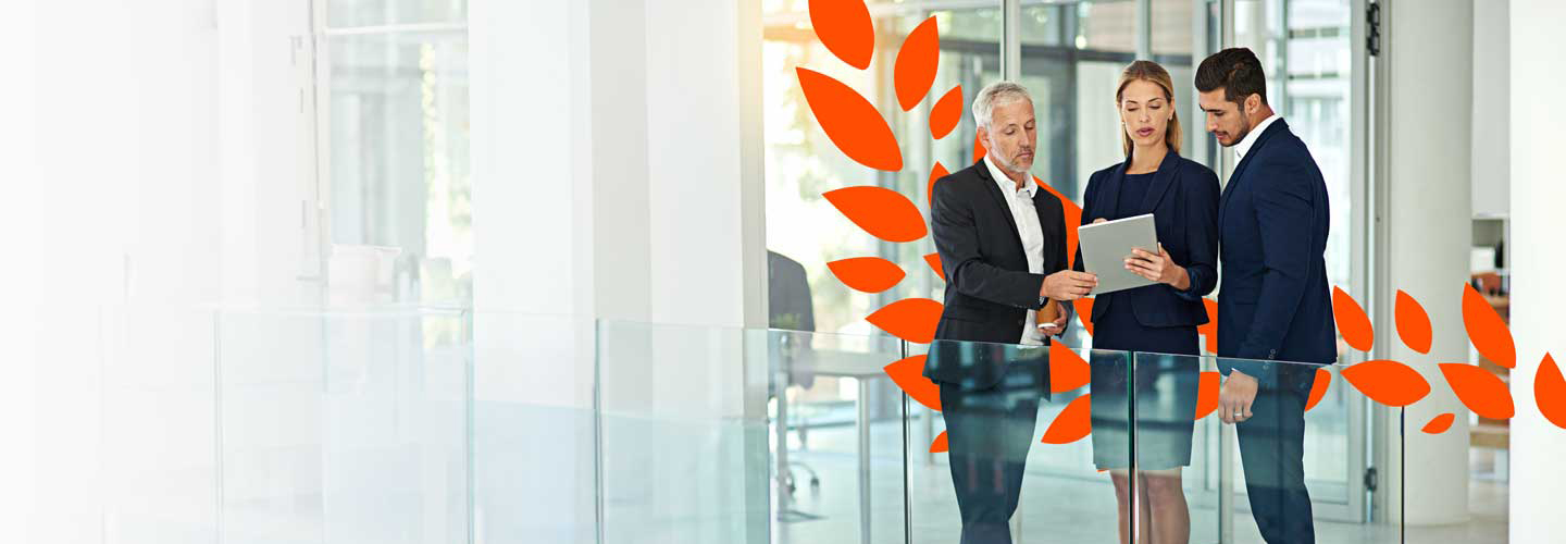 A group of people discuss while standing in a meeting room